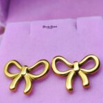 bow stud earrings stainless steel gold tone close view