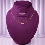 gold tone bow pendant necklace with crystal stones full view