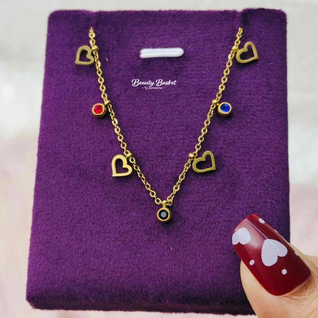 gold tone heart charm necklace with red blue stones full view