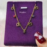 gold tone heart charm necklace with red blue stones full view