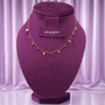 gold tone charm necklace with red green stones stylish full view
